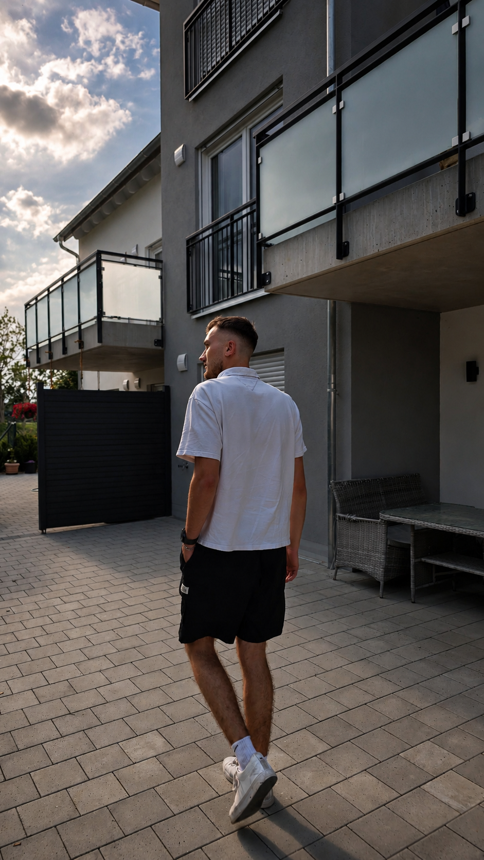 Lucas Pohl walking past a modern building in evening light